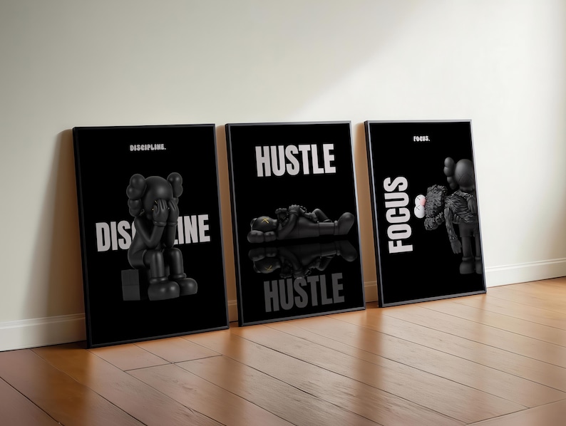 May include: Three framed black and white art prints. Each print features a black figure with white text. The prints read "DISCIPLINE", "HUSTLE", and "FOCUS". The figures are in different poses.
