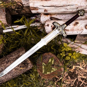May include: A detailed sword with a silver blade and ornate gold and silver hilt. The handle is dark brown. The sword rests on a bed of wood logs and greenery, creating a rustic and fantasy-themed aesthetic.