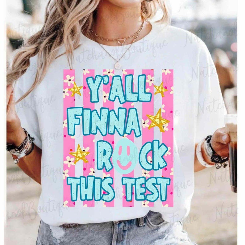 A person wearing a white t-shirt with a colorful graphic design that says "Y'ALL FINNA ROCK THIS TEST" in bold letters.