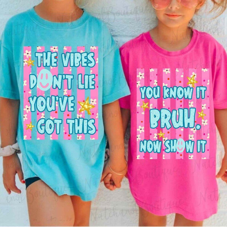 Two children wearing matching t-shirts with motivational text printed on them.