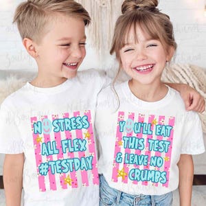 Two children wearing white t-shirts with text and graphics printed on them, smiling and posing together.