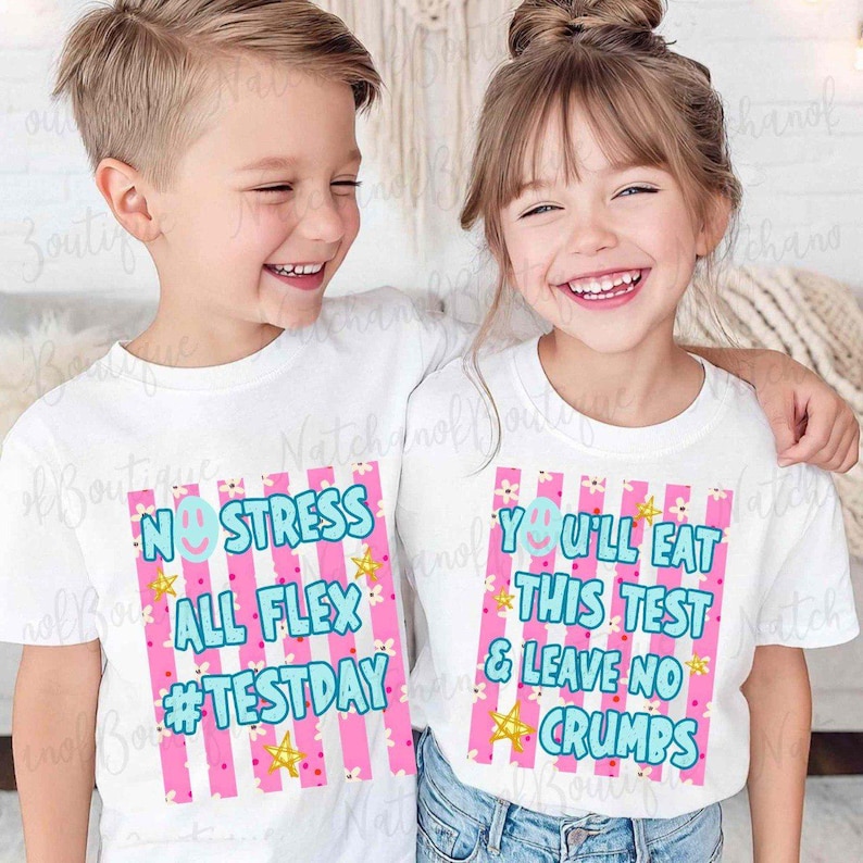 Two children wearing white t-shirts with text and graphics printed on them, smiling and posing together.