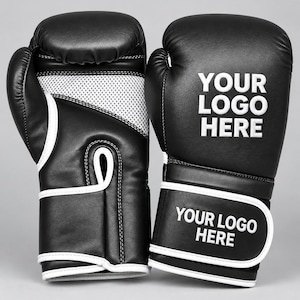 May include: A pair of black boxing gloves with white trim and mesh palm detailing. The gloves feature the white text "YOUR LOGO HERE" printed on the back of the hand and on the adjustable wrist strap, providing a clear area for custom branding.
