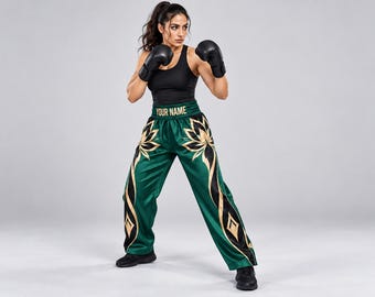 May include: Satin boxing shorts in deep green featuring a wide waistband with the text YOUR NAME in gold. The shorts are decorated with large gold and black lotus-style floral patterns on the front panels and down the sides of the legs.