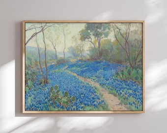 May include: A framed landscape painting depicting a field of bluebonnet flowers in shades of blue and purple, with a dirt path winding through the center. Green prickly pear cacti and thin, bare trees are scattered throughout the scene.