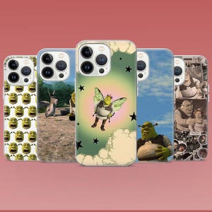 Puede incluir: Cinco fundas para teléfono con personajes de Shrek. Las fundas muestran imágenes de Shrek, Asno y otros personajes de la película animada. Las fundas tienen un borde transparente y están sobre un fondo degradado rojo.