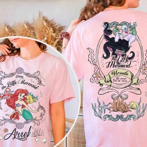 May include: Pale pink t-shirt with graphics from Disney's The Little Mermaid. The front displays Ariel, Flounder, and Sebastian. The back shows Ursula with the text "The Little Mermaid" and "Ursula, The ocean will be mine."