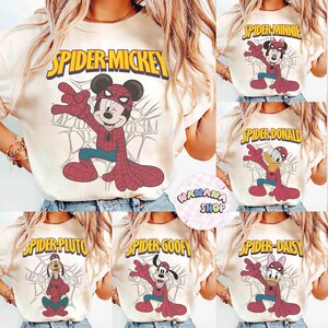 May include: Cream-colored t-shirts featuring various Disney characters as Spider-Man. Designs include Mickey, Minnie, Donald, Pluto, Goofy, and Daisy. Each shirt has a character in a Spider-Man suit with the character's name above.