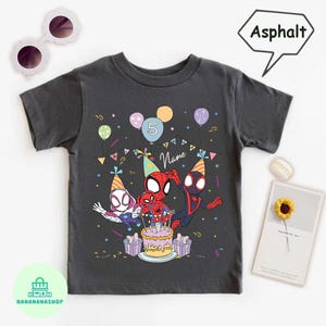 Puede incluir: Camiseta gris asfalto con personajes de Spider-Man celebrando un cumplea&ntilde;os. El dise&ntilde;o incluye una tarta, globos y el n&uacute;mero 5. La palabra "Name" tambi&eacute;n es visible en la camiseta.