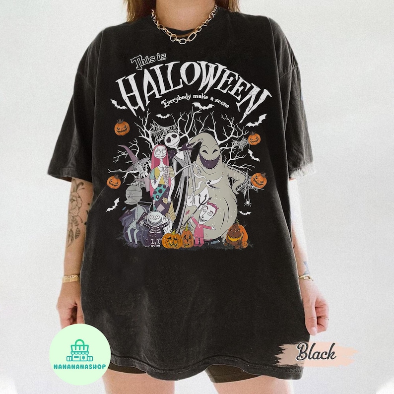 May include: Black t-shirt featuring a Halloween design with the text "This is Halloween" and various characters. The design includes Jack Skellington, Sally, and Oogie Boogie, along with pumpkins and bats.