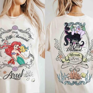 May include: Cream-coloured t-shirt featuring Disney's The Little Mermaid. The front graphic shows Ariel, Flounder, and Sebastian. The back graphic features Ursula. Text includes "The Little Mermaid", "Sparkle Always Make Waves!", and "Ursula The ocean will be mine."