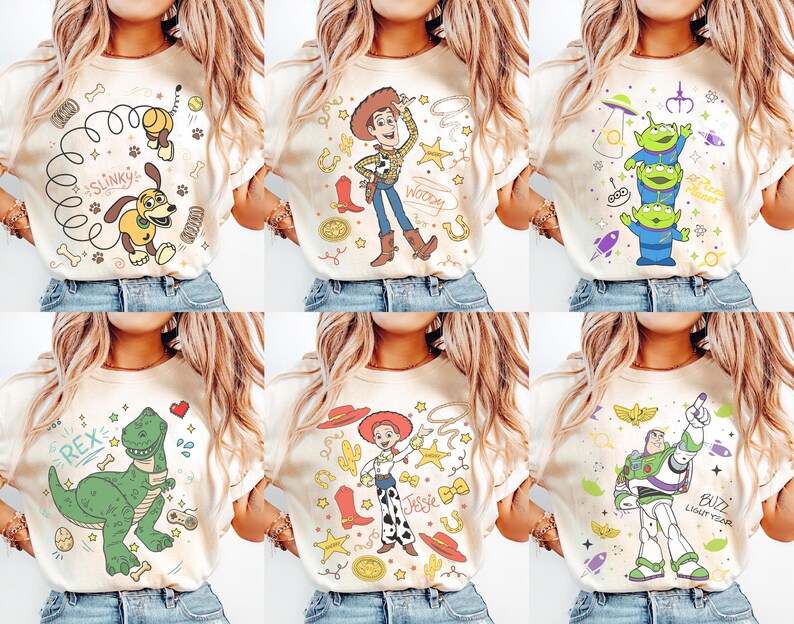 K&ouml;nnte beinhalten: Sechs cremefarbene T-Shirts, jedes mit einem anderen Cartoon-Charakter-Design. Designs umfassen Slinky Dog, Woody, drei gr&uuml;ne Aliens, Rex den Dinosaurier, Jessie und Buzz Lightyear.