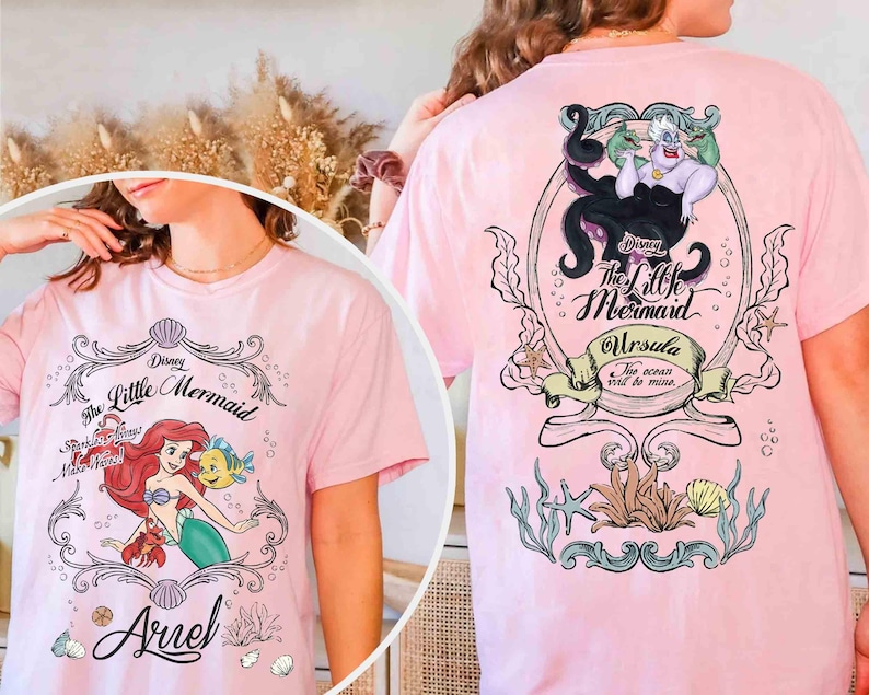 May include: Pale pink t-shirt with graphics from Disney's The Little Mermaid. The front displays Ariel, Flounder, and Sebastian. The back shows Ursula with the text "The Little Mermaid" and "Ursula, The ocean will be mine."
