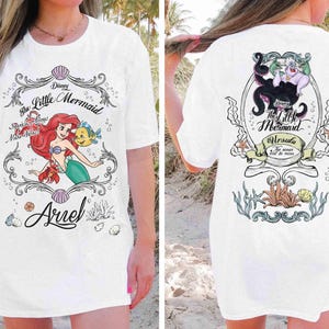 May include: White t-shirt with a front illustration of Ariel from Disney's The Little Mermaid, with the text "Ariel" and "Sparkling Seas Make Waves!". The back features Ursula and the text "Ursula The ocean will be mine."