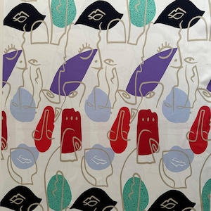 Könnte beinhalten: Weißer Stoff mit einem sich wiederholenden Muster aus abstrakten Gesichtern und Formen in Schwarz, Lila, Rot, Türkis und Hellblau. Die Gesichter sind mit einer dünnen, neutralen Farbe umrandet, wodurch ein modernes Design entsteht.
