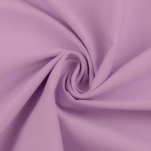 Op de afbeelding: Close-up van een stofstaal in een zachte lavendelkleur. De stof is strak geweven, met subtiele verticale lijnen zichtbaar. Het materiaal is verzameld en gedraaid, waardoor zachte plooien en schaduwen ontstaan. De algehele textuur lijkt glad en licht glanzend.