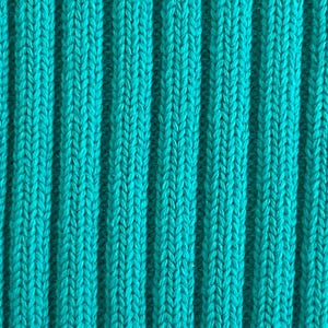 May include: Close-up of a teal ribbed knit fabric. The fabric has vertical ridges and a textured surface. The color is a vibrant, solid teal, with a slight sheen. The knit pattern is visible, creating a visually interesting texture.