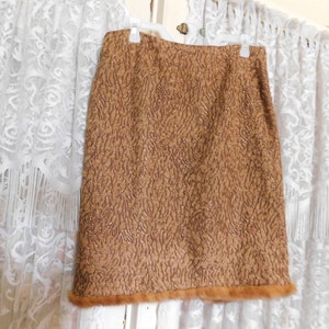 Puede incluir: Una falda marrón con un patrón texturizado y un ribete de piel marrón.