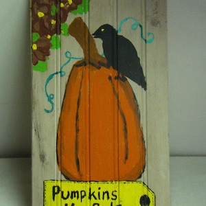May include: A hand-painted wooden sign with a pumpkin and a black bird. The sign is painted in shades of orange, brown, green, and black. The sign has the text "Pumpkins 4- Sale" on a yellow tag.
