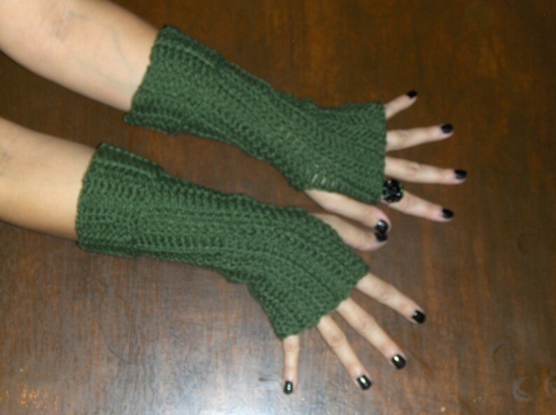 May include: A pair of green fingerless gloves made of crocheted yarn.