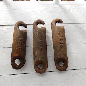 May include: Three rusty metal hooks with a loop at the bottom and a hook at the top. The hooks are labelled "F.S.H.I.P", "H.O.I.P", and "W.C.S.I.P".