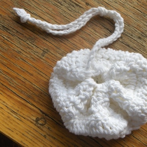 May include: White crocheted drawstring bag with a round shape and a knotted cord.
