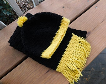 Conjunto de gorro con pompón y bufanda con flecos, colores del equipo negro y amarillo. Colores escolares. Mascota de los colores universitarios.