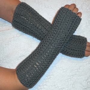May include: A pair of gray crocheted fingerless gloves. The gloves are made with a simple stitch pattern and have a loose fit.