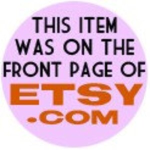May include: A round, light purple sticker with black text that reads "THIS ITEM WAS ON THE FRONT PAGE OF ETSY.COM" in a bold, orange font. The sticker is likely used to promote an Etsy shop or product.