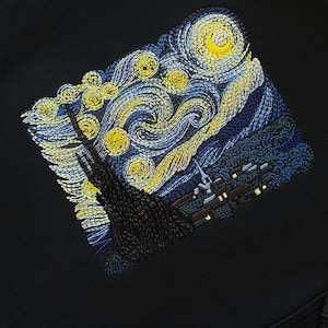 Puede incluir: Sudadera negra con una gran imagen bordada de la pintura "La noche estrellada" de Vincent van Gogh en hilo amarillo, azul y blanco.