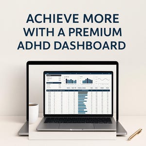 May include: A laptop displaying a data dashboard with the text "ACHIEVE MORE WITH A PREMIUM ADHD DASHBOARD." A white mug and a gold pen are on the table. The laptop screen shows charts and data tables.