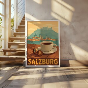 May include: A framed travel poster featuring a cup of coffee on a saucer, with two halves of a fruit, and the word "SALZBURG" in a brown font. The background depicts a mountain and buildings.