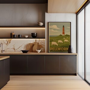 Könnte beinhalten: Kücheninterieur mit einem gerahmten Poster, das einen Leuchtturm und Schafe auf einem grünen Hügel mit der Aufschrift "Pellworm" zeigt. Die Küche hat dunkle Schränke, Arbeitsplatten aus Holz und eine Marmorrückwand. Eine schwarze Vase steht auf der Theke.