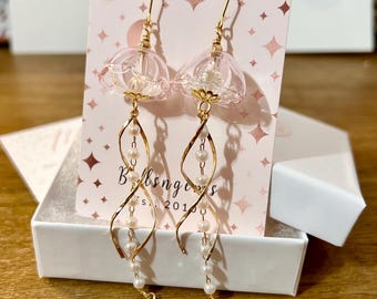 Pendientes colgantes de cadena dorada con medusas y perla de cristal rosa pálido translúcido iridiscente. Un regalo para ella.