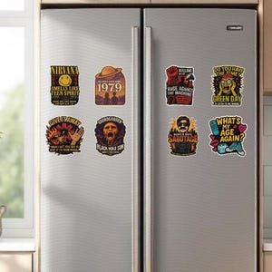 May include: A collection of eight rectangular magnets with band logos and song titles, including Nirvana, Soundgarden, and Green Day. The magnets feature various colors and designs, with text like "Smells Like Teen Spirit" and "Sabotage."