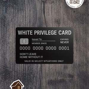 May include: A black card with the text "WHITE PRIVILEGE CARD" in white. The card has a credit card chip design, a space for "Issued To:" and the text "DON'T LEAVE HOME WITHOUT IT". The card is on a wooden background.