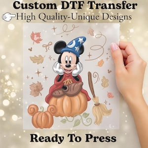 May include: A custom DTF transfer sheet featuring a cartoon mouse wearing a blue wizard hat with a white moon and stars, a red cape, and sitting on a pumpkin. The design includes a broom, autumn leaves, and text reading Custom DTF Transfer.