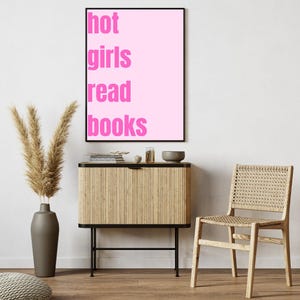 Könnte beinhalten: Ein rosa gerahmtes Poster mit dem Text "hot girls read books" in weißen Buchstaben.