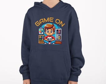 May include: A navy blue hooded sweatshirt with a graphic of a cartoon boy playing video games. The text "GAME ON" is printed in yellow above the graphic.