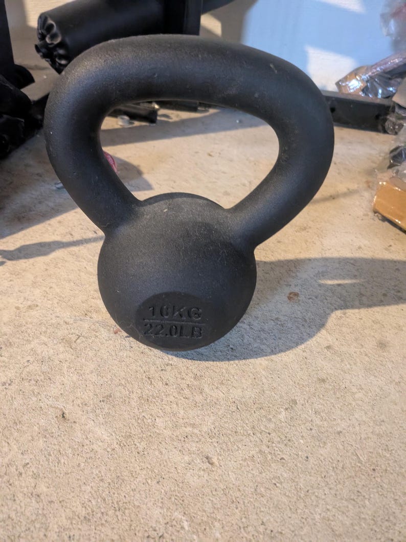May include: Black cast iron kettlebell with a handle. The kettlebell weighs 10kg or 22.01lb.