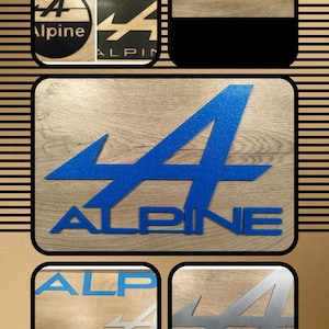 Peut inclure: Un collage d'images présentant le logo Alpine. Le logo est affiché dans différents styles et matériaux, notamment un design bleu pailleté sur fond de bois. D'autres images montrent le logo en noir et argent, avec le texte "ALPINE" visible.