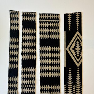May include: Four rectangular fabric strips featuring a repeating geometric pattern in black and beige. The designs include rows of triangles and diamond shapes arranged in vertical columns, with raw, unfinished edges visible on each piece of textile.