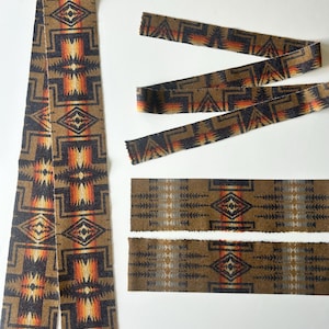 May include: A collection of fabric strips featuring a repeating geometric pattern in shades of brown, black, orange, and yellow. The design includes diamond shapes and linear motifs arranged in a continuous, symmetrical, and repeating layout.