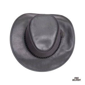 Pode incluir: Chap&eacute;u de cowboy de couro preto com copa arredondada e aba larga. O chap&eacute;u apresenta uma faixa de malha ao redor da copa e uma borda costurada decorativa. Projetado para prote&ccedil;&atilde;o solar e atividades ao ar livre.