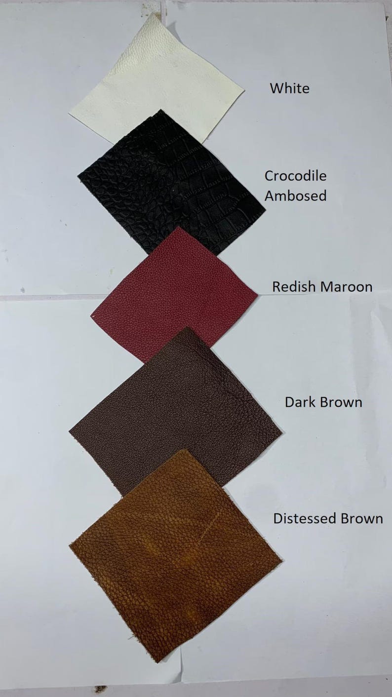 Pode incluir: Amostras de couro em branco, preto com relevo de crocodilo, vermelho-marrom, marrom escuro e marrom envelhecido. Cada amostra &eacute; rotulada com o nome da cor.