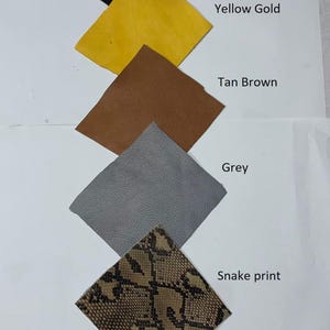 May include: A collection of leather swatches in various colors and textures. The swatches include black, yellow gold, tan brown, grey, and a snake print. Each swatch is labeled with its corresponding color or pattern name.