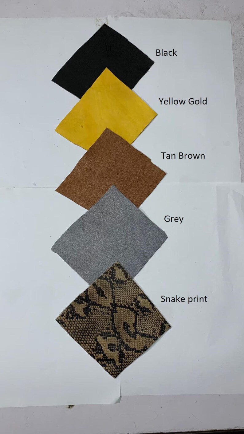 May include: A collection of leather swatches in various colors and textures. The swatches include black, yellow gold, tan brown, grey, and a snake print. Each swatch is labeled with its corresponding color or pattern name.