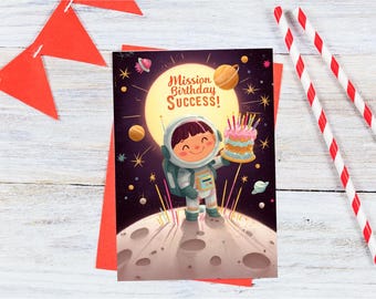 May include: A birthday card featuring an astronaut holding a birthday cake with the text "Mission Birthday Success!" on a dark blue background with stars and planets.