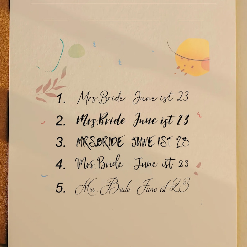 May include: A cream-colored paper with handwritten calligraphy. The text reads "Mrs. Bride June 1st 23" repeated five times. Decorative watercolor accents in pink, blue, and yellow are scattered around the text.