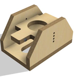 May include: A wooden jig with a cutout in the shape of a T. The jig has a series of holes drilled into the side.